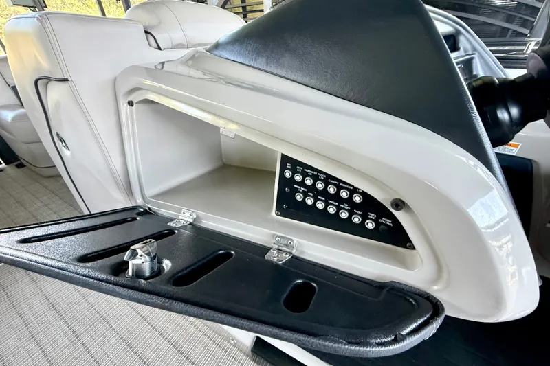 Slide: The Image of 2019 Barletta L23QC SS boat dashboard with open storage compartment and control panel. - 37
