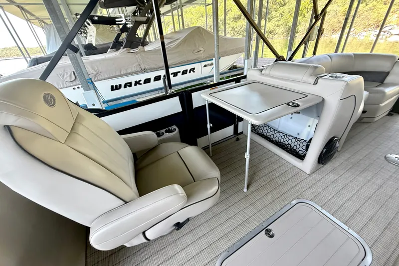 Slide: The Image of 2019 Barletta L23QC SS pontoon boat interior with plush seating and table setup. - 32