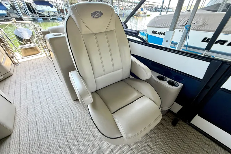 Slide: The Image of Captain's chair on 2019 Barletta L23QC SS pontoon boat, docked with other boats nearby. - 40
