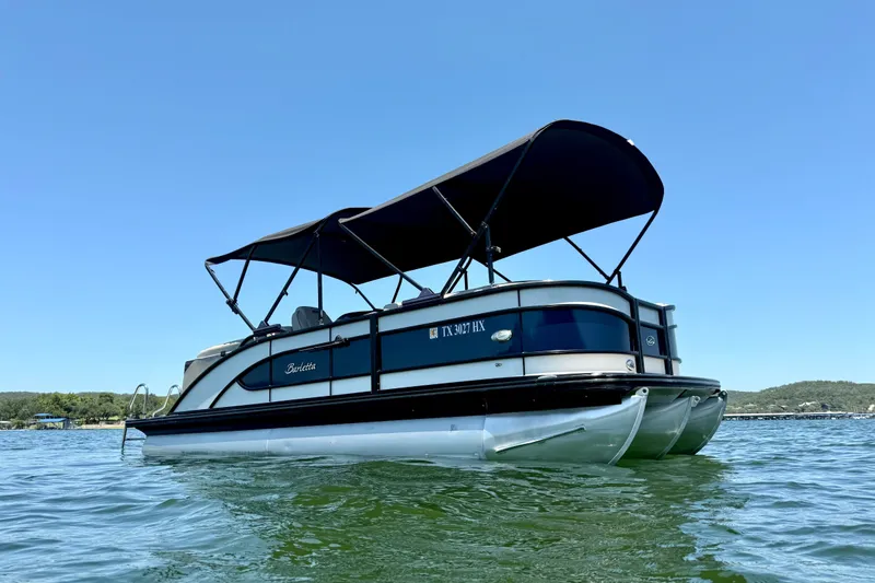 The Image of 2019 Barletta L23QC SS pontoon boat on calm water under clear blue sky. - 2