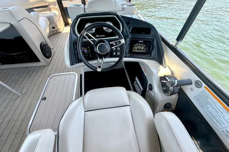 Slide: The Image of 2019 Barletta L23QC SS boat interior with steering wheel and control panel. - 24