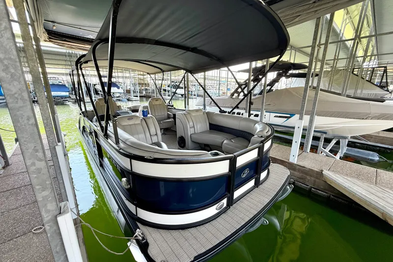 Slide: The Image of 2019 Barletta L23QC SS pontoon boat docked in a marina, featuring spacious seating. - 34