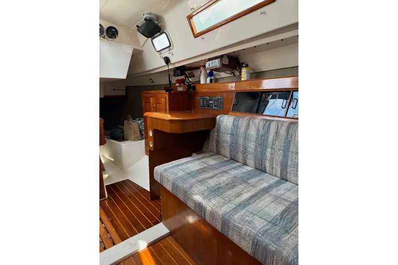 Slide: The Image of Interior of a 1987 Hunter 31 sailboat with wood paneling and cushioned seating. - 5