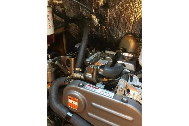 Slide: The Image of Engine compartment of a 1987 Hunter 31 sailboat, showcasing mechanical components and hoses. - 12
