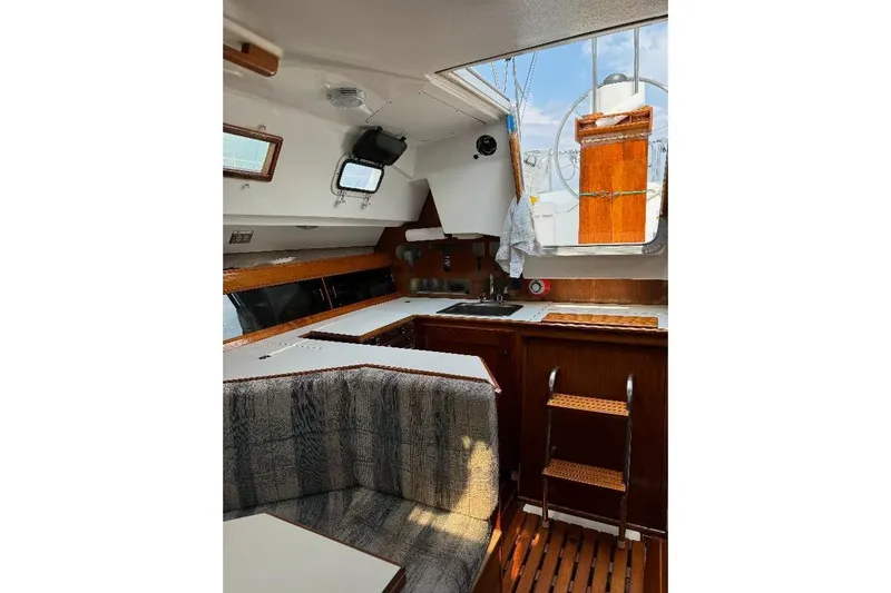 Slide: The Image of Interior of a 1987 Hunter 31 sailboat featuring a cozy cabin with seating and kitchenette. - 8