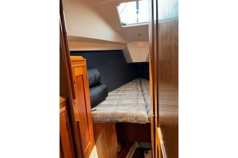 Slide: The Image of Cozy cabin interior of 1987 Hunter 31 sailboat with wooden furnishings and bedding. - 10