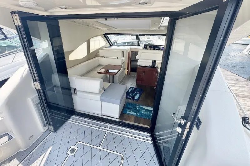 Slide: The Image of Interior view of 2019 Carver C37 yacht with open glass doors and white seating. - 21