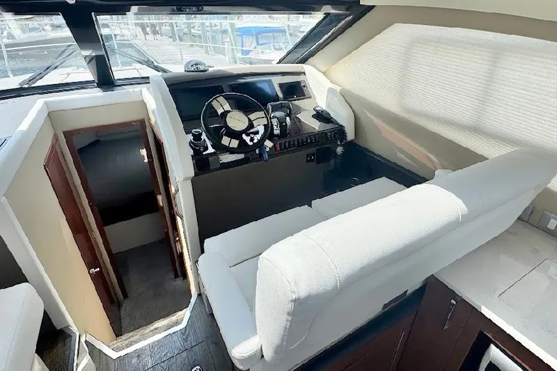 Slide: The Image of Interior of 2019 Carver C37 yacht, featuring helm station and seating area. - 16