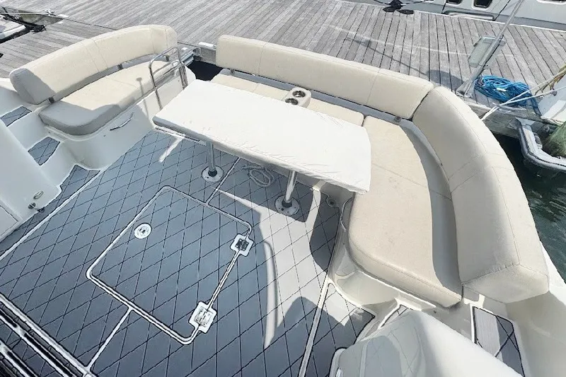 Slide: The Image of Spacious seating area on 2019 Carver C37 yacht with cushioned benches and table. - 13