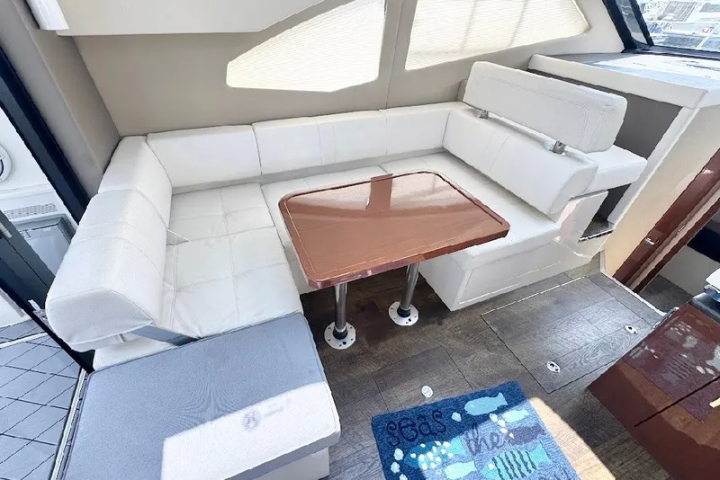 Slide: The Image of Interior of 2019 Carver C37 yacht with white seating and wooden table. - 19