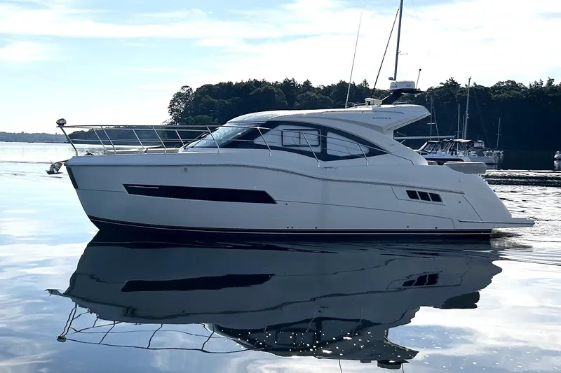 Slide: The Image of 2019 Carver C37 yacht on calm water, reflecting the serene surroundings. - 6