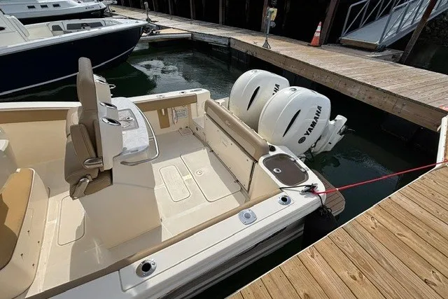 Slide: The Image of 2021 Scout 255 LXF boat with twin Yamaha engines docked at a marina. - 9