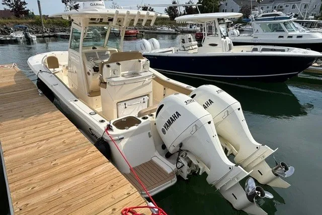 Slide: The Image of 2021 Scout 255 LXF boat docked, featuring twin Yamaha engines, in a marina setting. - 3