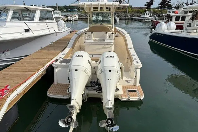 Slide: The Image of 2021 Scout 255 LXF boat docked with twin 150 engines at a marina. - 2