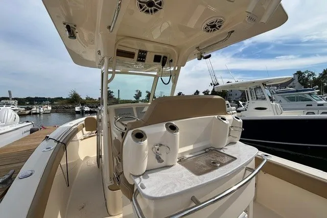 Slide: The Image of 2021 Scout 255 LXF boat interior with helm, docked at marina. - 13