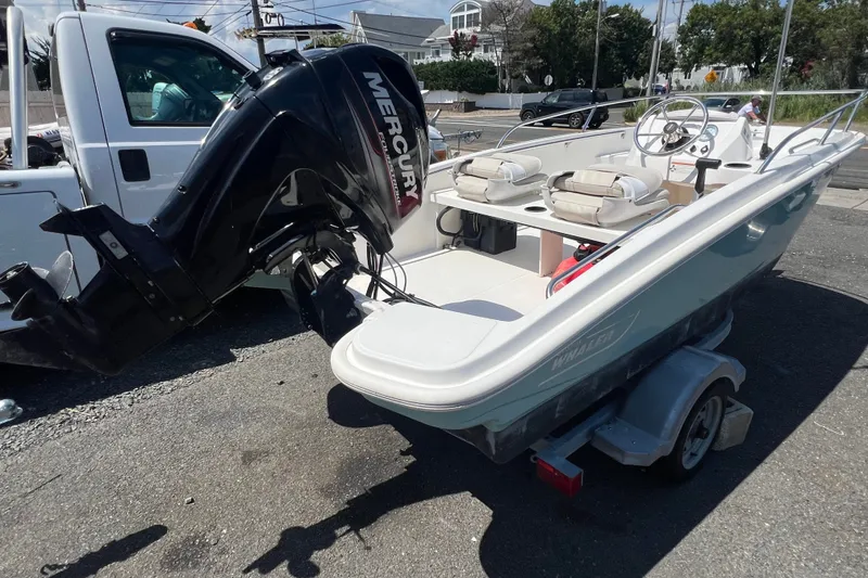 Slide: The Image of 2019 Boston Whaler 130 Super Sport boat with Mercury engine on trailer. - 3