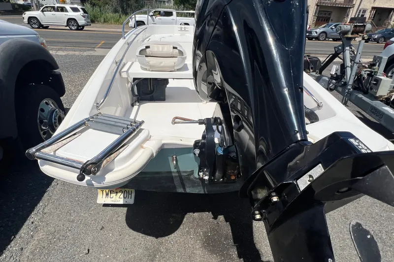 Slide: The Image of 2019 Boston Whaler 130 Super Sport boat with outboard motor and ladder, parked on a trailer. - 6