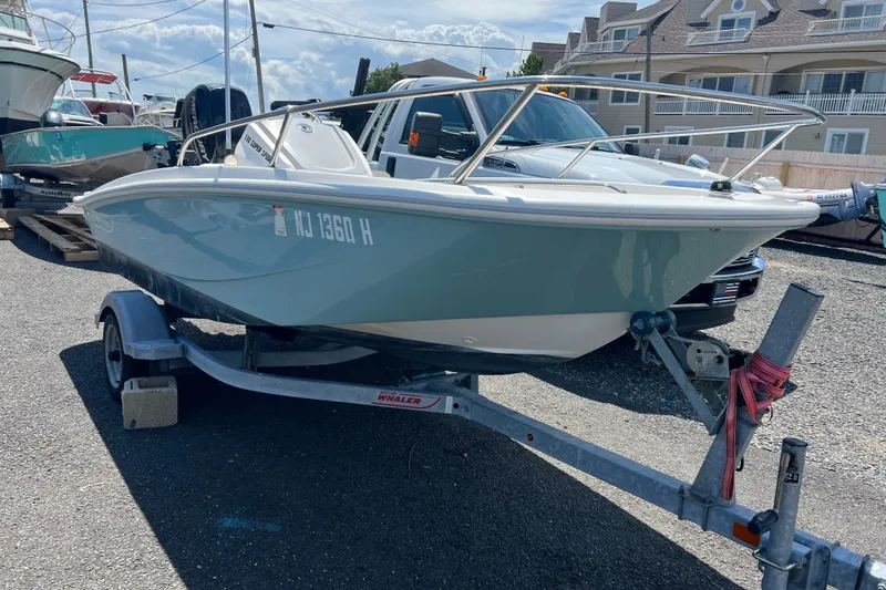 Slide: The Image of 2019 Boston Whaler 130 Super Sport boat on trailer, parked outdoors. - 1