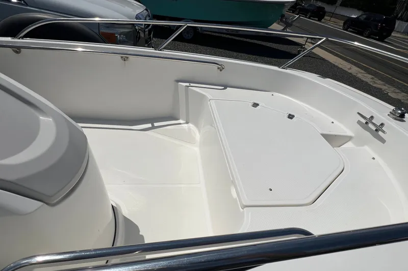 Slide: The Image of 2019 Boston Whaler 130 Super Sport boat interior with white seating and stainless steel railings. - 5