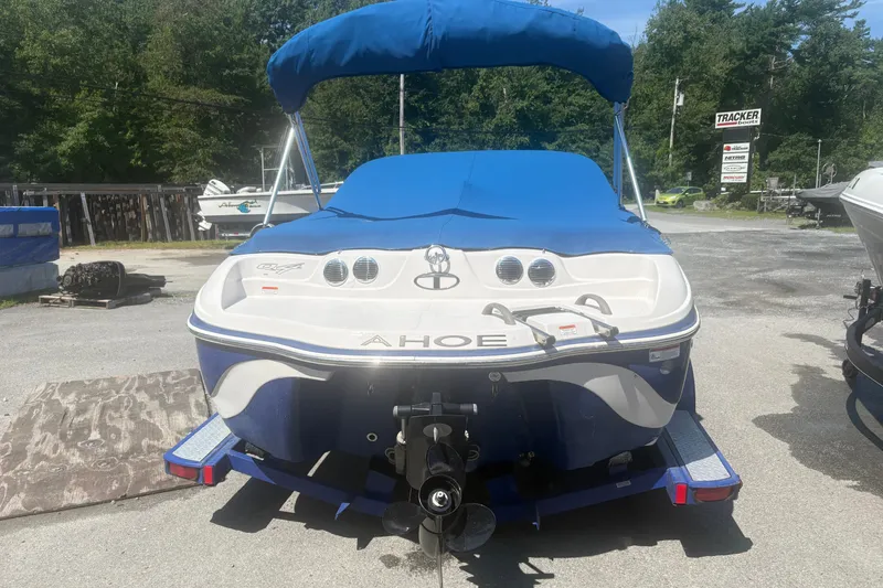 Slide: The Image of 2011 Tahoe Q4 SF boat with blue cover, parked outdoors on a sunny day. - 3