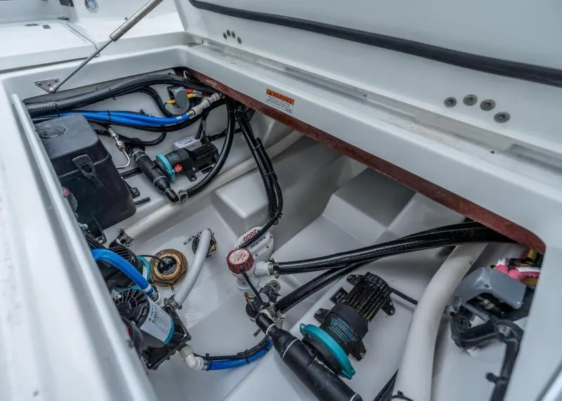 Slide: The Image of A view inside the engine compartment of a 2024 Blackfin 272 CC boat with various hoses and equipment. - 17
