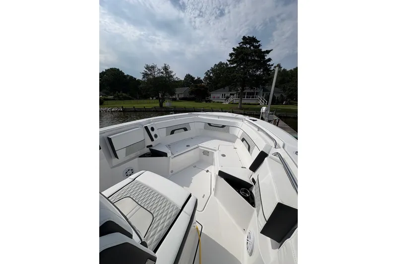 Slide: The Image of 2024 Blackfin 272 CC boat interior with seating, docked by a waterfront property. - 33
