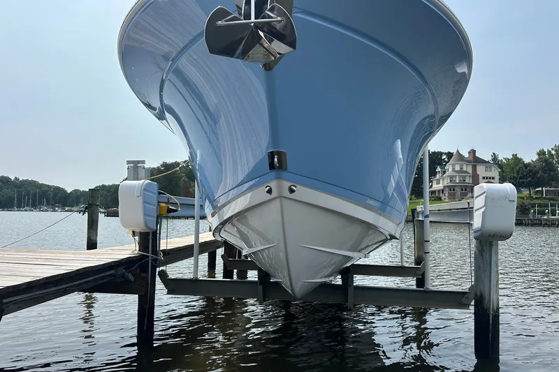 Slide: The Image of 2024 Blackfin 272 CC boat docked on a lift, showcasing sleek blue hull design. - 4