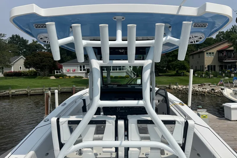 Slide: The Image of 2024 Blackfin 272 CC boat docked, showcasing seating and rod holders. - 22