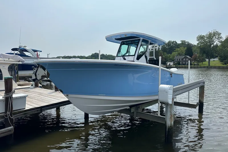 The Image of 2024 Blackfin 272 CC boat docked on a calm lake. - 0