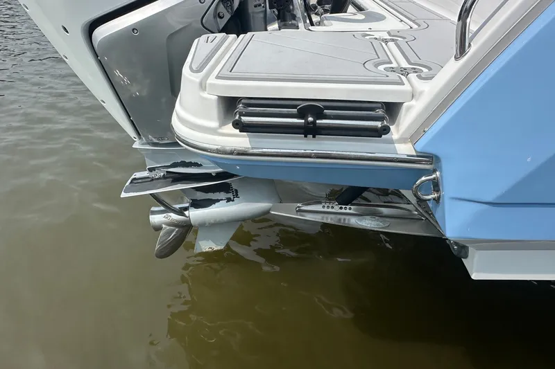 Slide: The Image of 2024 Blackfin 272 CC boat stern with propeller and swim platform in water. - 12
