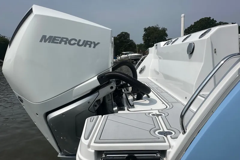 Slide: The Image of 2024 Blackfin 272 CC boat with Mercury engine, docked on calm water. - 11