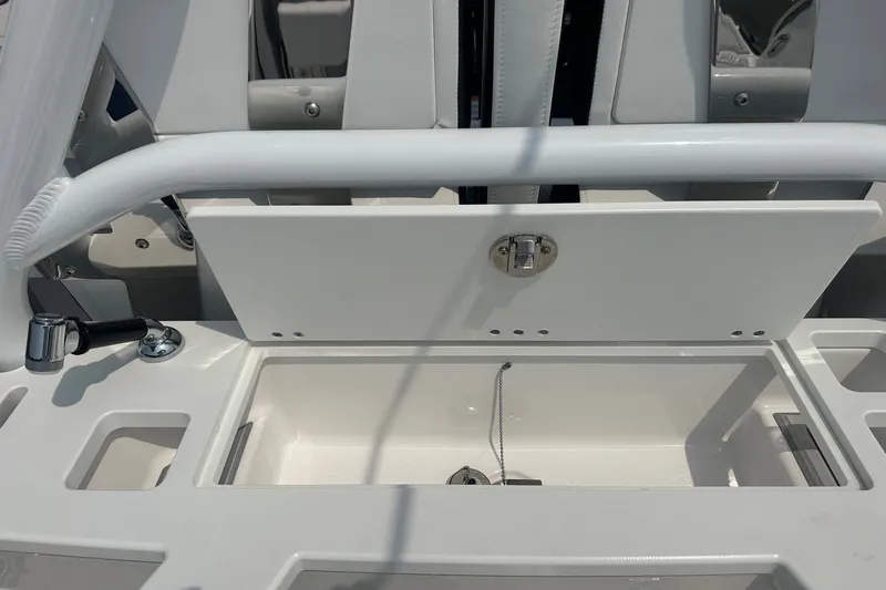 Slide: The Image of 2024 Blackfin 272 CC boat storage compartment with latch and cup holder. - 19