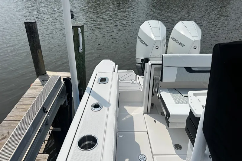 Slide: The Image of 2024 Blackfin 272 CC boat with dual Mercury engines docked by the water. - 13