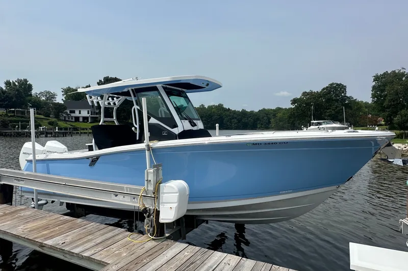 Slide: The Image of 2024 Blackfin 272 CC boat docked on a serene waterfront. - 3