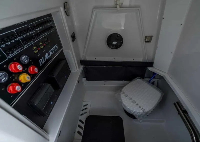 Slide: The Image of The image shows the interior of a 2024 Blackfin 272 CC boat with a control panel and toilet. - 25