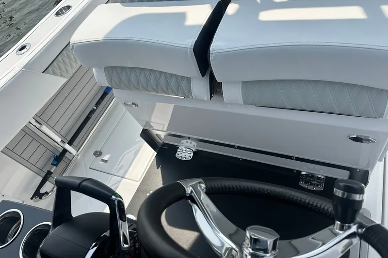 Slide: The Image of 2024 Blackfin 272 CC boat interior with steering wheel and cushioned seating. - 24