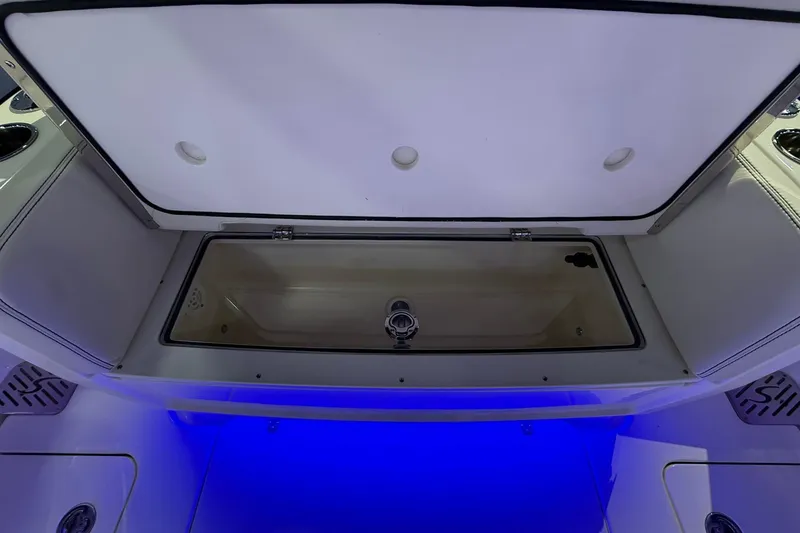 Slide: The Image of 2026 Scout 288 Dorado boat storage compartment with blue LED lighting. - 24
