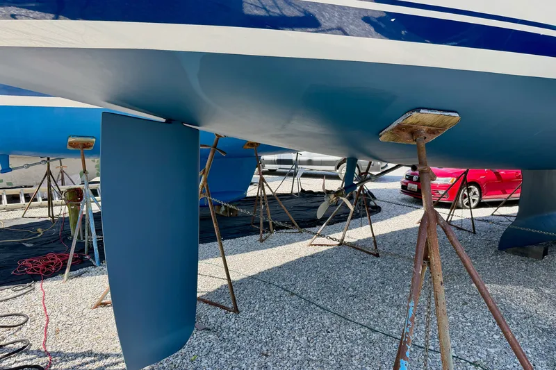 Slide: The Image of 2004 Jeanneau Sun Odyssey 43 DS sailboat on stands, showcasing hull and rudder. - 61