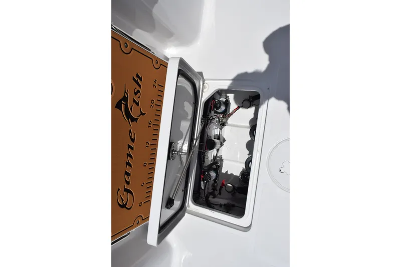 Slide: The Image of 2027 Sea Hunt Gamefish 27FS boat compartment with open hatch and visible equipment. - 23