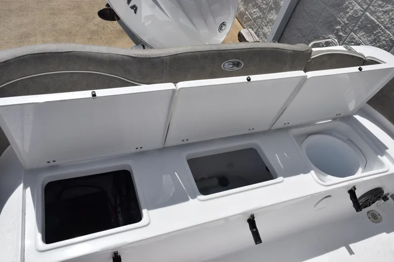 Slide: The Image of 2027 Sea Hunt Ultra 229 boat storage compartments with open lids, showcasing interior features. - 19