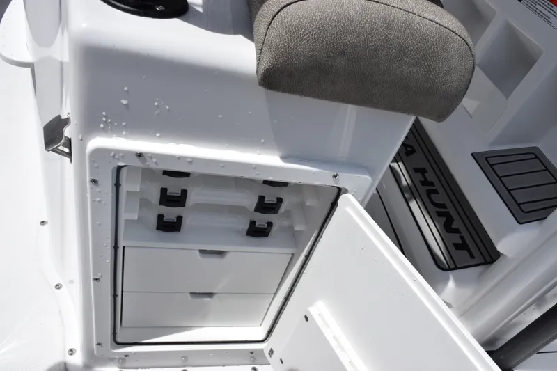 Slide: The Image of 2027 Sea Hunt Ultra 229 boat storage compartment with tackle boxes and seating. - 18