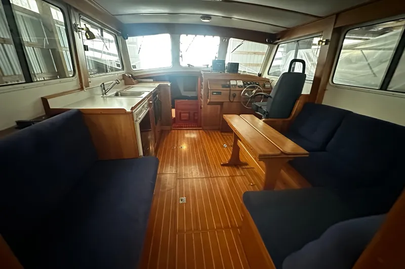 Slide: The Image of Interior of 1998 Northern Bay 36 boat with wooden flooring and blue seating. - 25