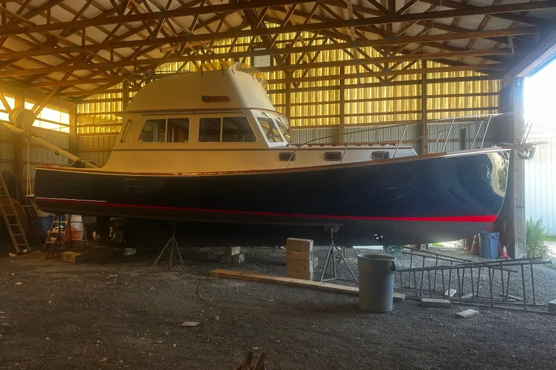 Slide: The Image of 1998 Northern Bay 36 boat in a wooden shed, elevated on supports. - 3
