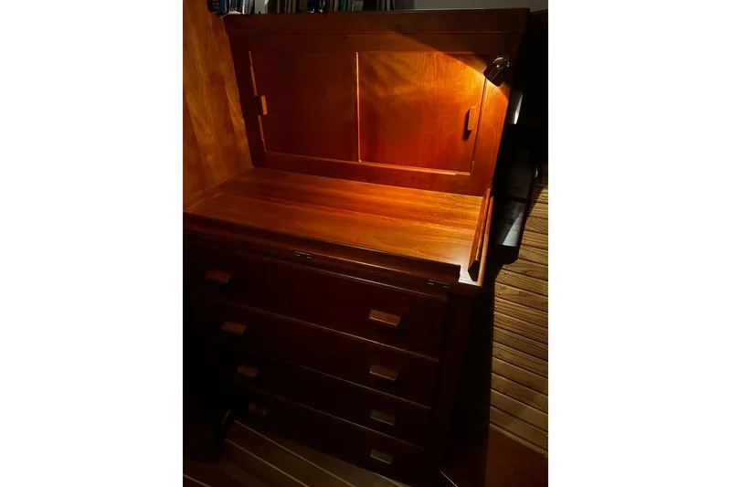 Slide: The Image of Wooden cabinet with drawers and open top compartment, illuminated warmly, aboard a 1998 Northern Bay 36. - 13