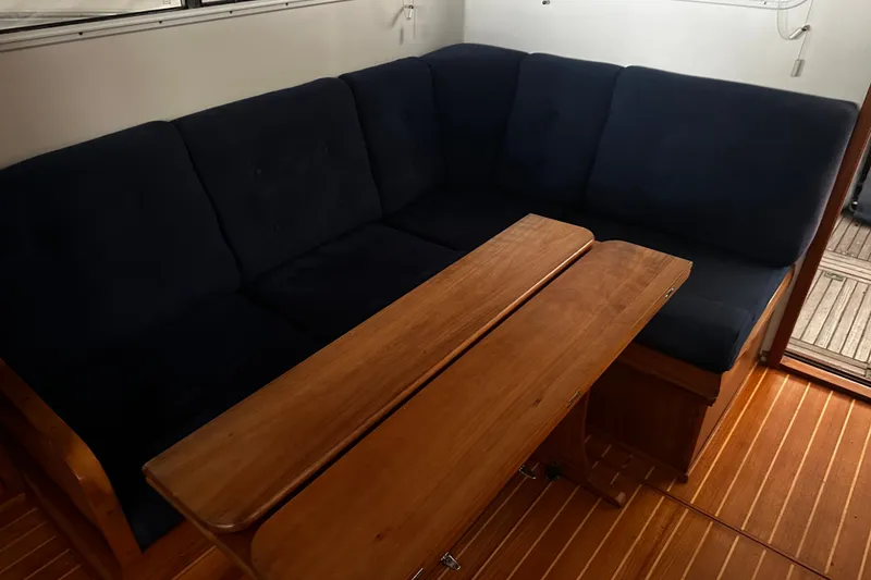 Slide: The Image of Cozy interior of 1998 Northern Bay 36 with navy seating and wooden table. - 15