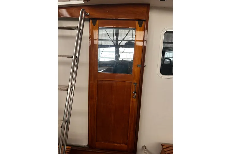 Slide: The Image of Wooden cabin door on 1998 Northern Bay 36 boat, featuring a metal ladder. - 23