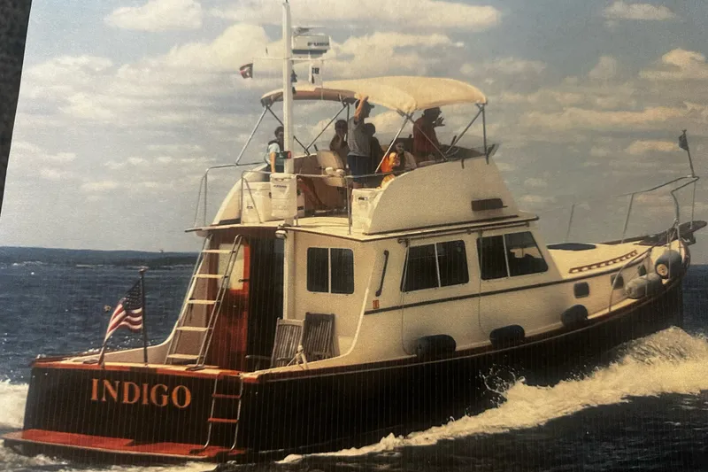 Slide: The Image of 1998 Northern Bay 36 boat "Indigo" cruising on open water under a partly cloudy sky. - 2