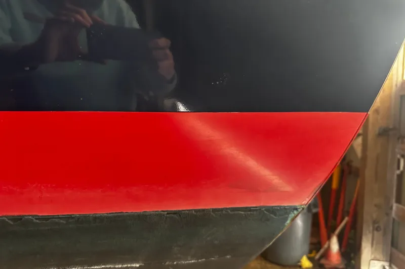 Slide: The Image of Close-up of a 1998 Northern Bay 36 boat hull with red and black paint. - 18