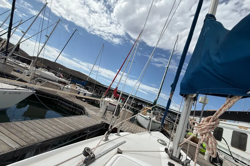 Slide: The Image of Sailboats docked at a marina, featuring a 1998 Catalina 250 under a partly cloudy sky. - 39