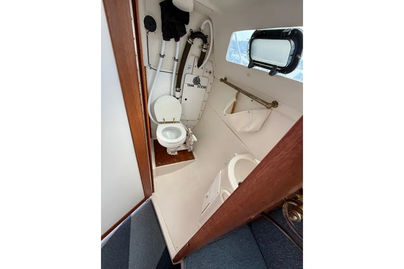 Slide: The Image of 1998 Catalina 250 boat interior with compact marine toilet and storage. - 20